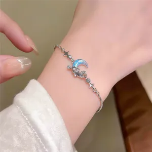 Close-up of sparkling zircon moon bracelet on female wrist with celestial design