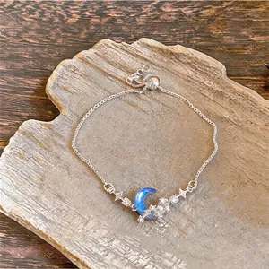 Detailed macro shot of silver adjustable moon bracelet with blue crescent and zircons