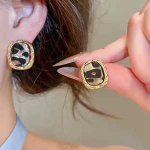 Detailansicht der Retro-Ohrstecker aus Acetat mit Leopardenmuster und Goldrand.
