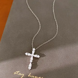 Vista detallada de un collar con colgante de cruz de circonita bañada en oro