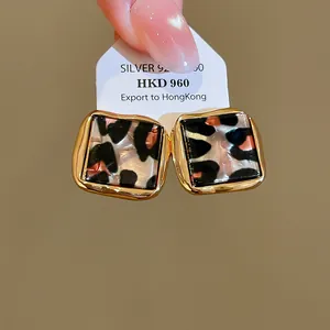 Nahaufnahme von quadratischen Acetat-Ohrsteckern mit Leopardenmuster und 14k Gold