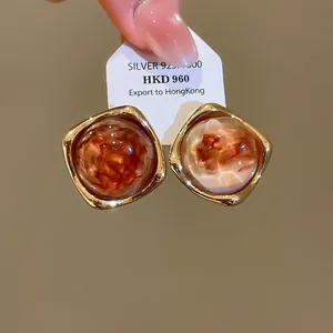Detailansicht der 14k vergoldeten Acetat-Ohrstecker mit Bernsteinmuster