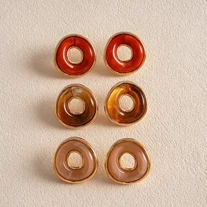 Set aus Vintage-Acryl-Ohrsteckern in Orange, Bernstein und Beige, geometrisches Design.