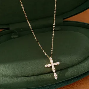 Detalle de collar de cruz chapado en oro de 18k con brillantes circonitas marquesa.