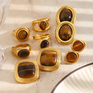 Gedetailleerd overzicht van vintage 18K vergulde ringen en oorbellen met tijgeroogsteen