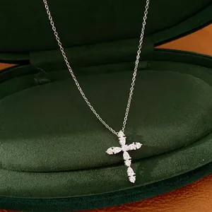 Detalle de primer plano de un collar de cruz bañado en oro de 18k con circonitas claras.