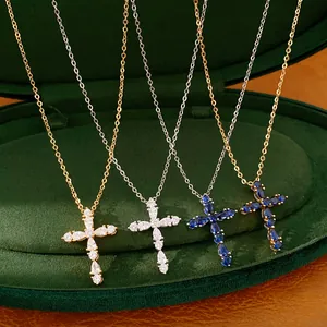 Detalle de collares cruz chapados en oro 18k con circonitas en estuche de terciopelo verde.