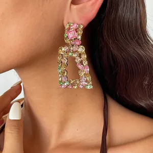 Close-up van vintage geometrische oorbellen met kleurrijke strass-steentjes en vergulding
