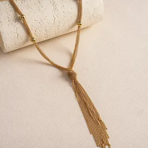 Nahaufnahme einer eleganten mehrlagigen Gold-Quastenkette mit feinen Metallketten