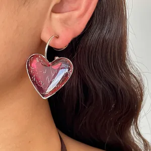 Gros plan d'une boucle d'oreille cœur en résine marbrée avec des éclats d'argent