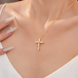Vista detallada de un collar de cruz chapado en oro de 18k con piedras de circón.