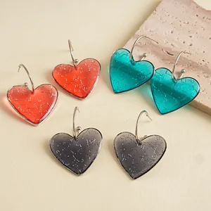 Vue détaillée des boucles d'oreilles cœur en résine marbrée rouge, bleu et gris avec tige