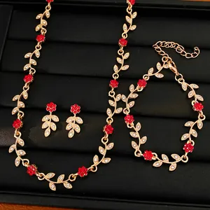 Close-up of gold-finish leaf and red flower jewelry set with sparkling rhinestones