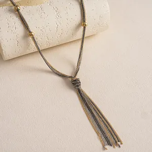 Detailansicht der mehrsträngigen Metall-Quastenkette mit Goldperlen auf einem Steinsockel.