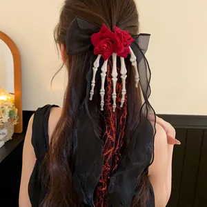 Detail of Halloween skeleton hand hair clip with red roses and black chiffon bow