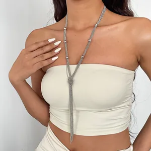 Detailansicht einer eleganten mehrlagigen Quastenkette in Silber an einem weiblichen Model.