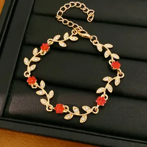 Elegant gold leaf and flower bracelet decorated with sparkling red and white rhinestones