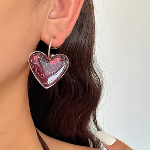 Gros plan d'une boucle d'oreille cœur en résine avec texture marbrée argent