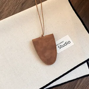 Detail view of brown suede glasses holder necklace with thin leather cord for women