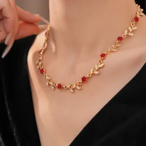 Close-up of gold-finish leaf and red flower necklace with sparkling rhinestones