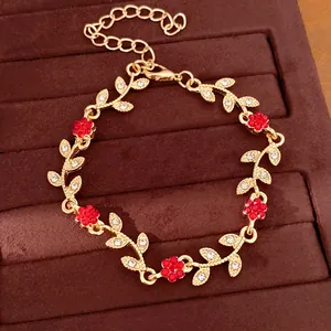 Close-up of elegant gold leaf bracelet with red floral rhinestones on brown velvet