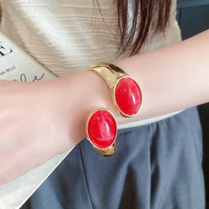 Detailed view of the red resin stones and gold finish on the vintage open cuff bracelet