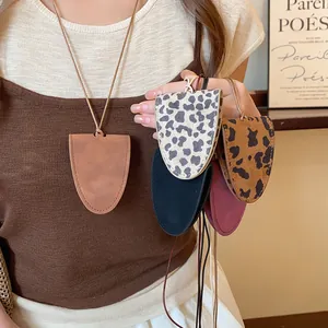 Close-up of multiple leopard print and solid faux leather eyeglass holder necklaces.