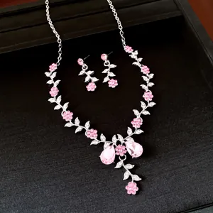 Detailed view of pink crystal flower and leaf necklace with matching earrings set