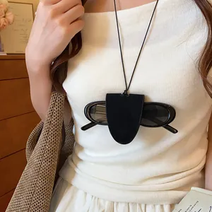 Detailed shot of a black leather eyeglasses holder necklace worn with sunglasses.