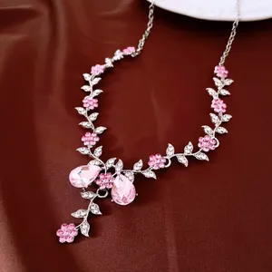 Macro view showing the intricate detail of an elegant silver necklace with pink rhinestone flowers