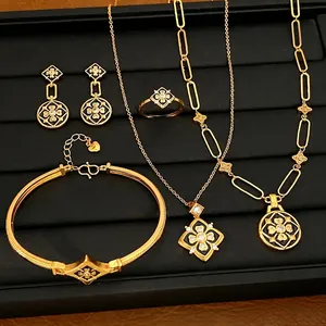Elegante conjunto de joyas florales bañadas en oro con esmalte negro y circonitas