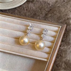 Elegant gold pearl stud earrings with sparkling cubic zirconia presented in jewelry box