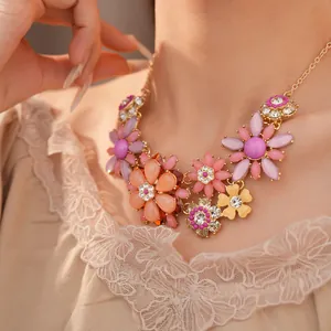 Close-up of a vintage acrylic flower necklace with sparkling rhinestones on a model.
