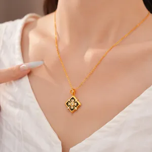 Detalle de collar con colgante de flor dorada, esmalte negro y circonitas