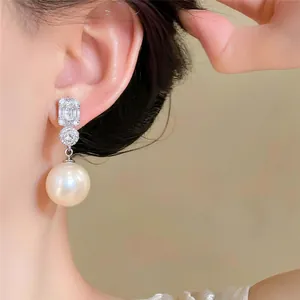 Detailopname van elegante Franse pareloorbellen met fonkelende zirkoon