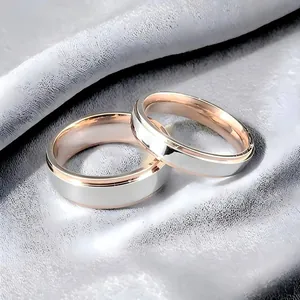 Gedetailleerde close-up van elegante tweekleurige roségouden en zilveren titanium stalen ringen