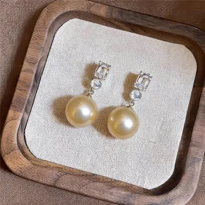 Close-up van elegante Franse stijl gouden parel oorbellen met zirkonia steentjes