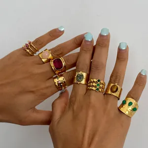 Close-up of gold stainless steel rings with tiger eye and natural stones.