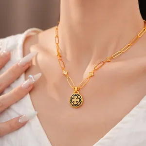 Primer plano de collar dorado con colgante de flor, esmalte negro y circonitas brillantes