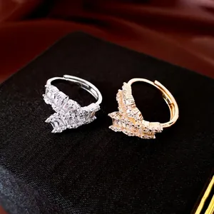 Sparkling 18k gold plated geometric open rings with baguette zircons shown on a black box