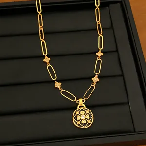 Imagen detallada de collar con colgante de flor bañado en oro con esmalte negro y circonita