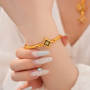 Vista macro de pulsera chapada en oro con esmalte negro y centro de circón brillante