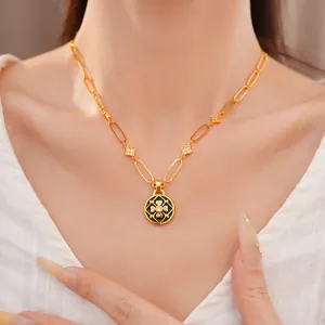 Detalle del collar con colgante de flor bañado en oro con circonitas y esmalte negro