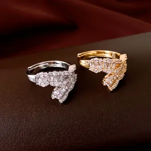 Primo piano dettagliato di anelli aperti placcati in oro 18k con zirconi su pelle scura