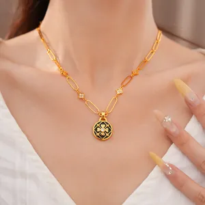Detalle de collar chapado en oro con esmalte negro y flores de circonita en una modelo.