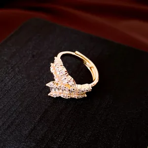 Dettaglio macro di anello aperto geometrico placcato oro 18k con zircone trasparente