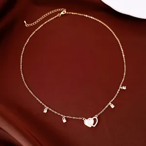 Detail showing 14k gold plated necklace with shell and cubic zirconia heart pendants