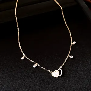 Close-up of 14k gold plated necklace with shell heart and sparkling zircon charms