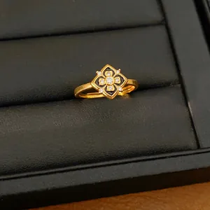 Primer plano detallado de un anillo de flor chapado en oro con esmalte y circonitas