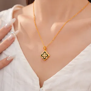 Primer plano de un collar con colgante de flor dorada, esmalte negro y piedras brillantes